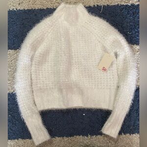 White fuzzy turtleneck sweater.